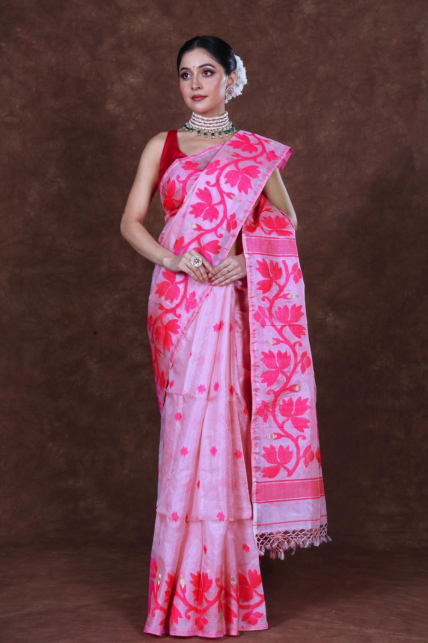 
Tussar Jamdani saree made from textured tussar silk featuring intricate handwoven Jamdani motifs in contrasting threads, with delicate floral and geometric patterns spread across the body and an ornate woven border, showcasing a soft golden-beige base with artisanal detailing.
